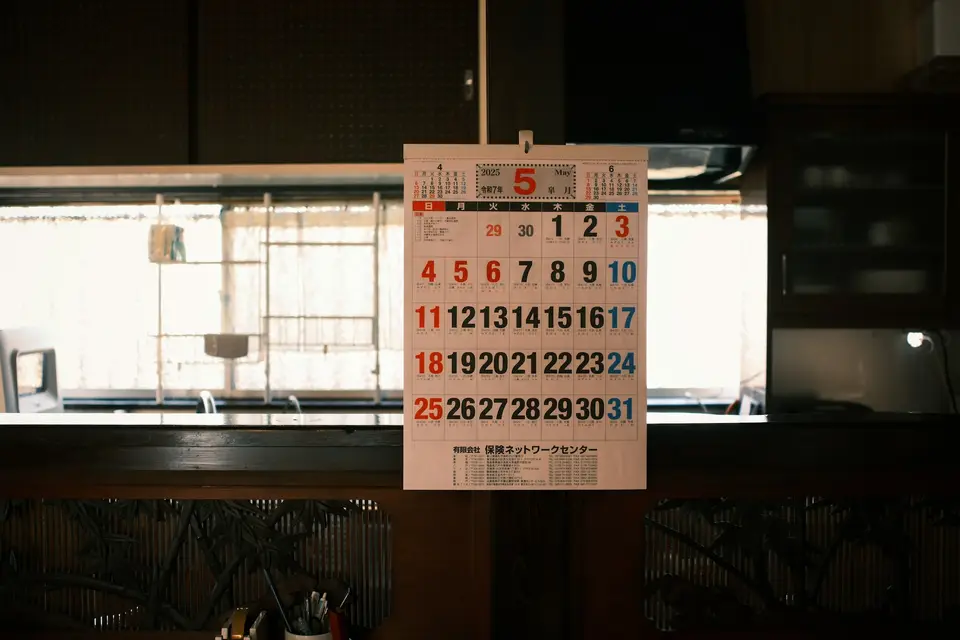 A wall calendar in a real kitchen, showing a month laid out in squares.